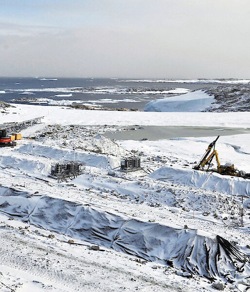 Piles of soil known as ‘biopiles’ under a protective covering in the snow at Casey station.
