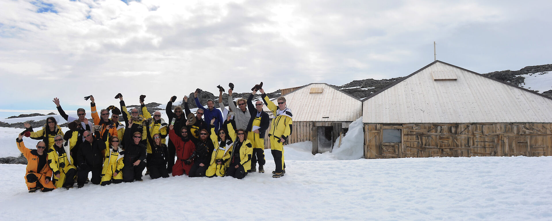 The Mawson’s Huts centenary team pose for a photograph in front of the huts.