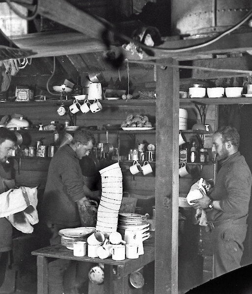 John Hunter (left), Alfred Hodgeman and ‘Robert’ Bage wash up in the living quarters of the Main Hut, 1912.