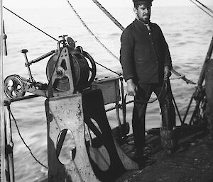 Aurora First Officer, F.D. Fletcher, with a Lucas sounding machine, which was used to delineate major features of the Southern Ocean sea floor.