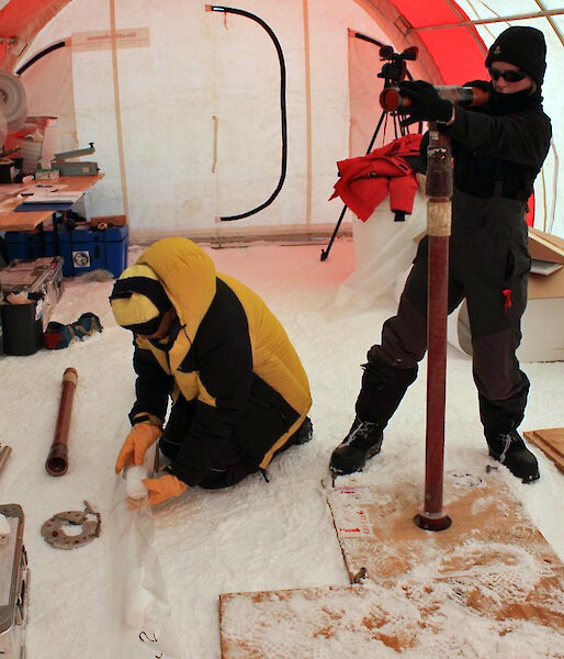 2 ice core scientists working in a drill tent in Antarctica