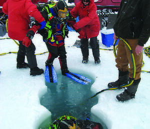Divers being assisted into dive holes in Antarctica.