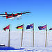 A Twin Otter flies over flags of countries participating in Antarctica’s Gamburtsev Province project.