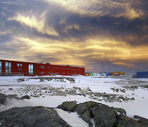A dramatic photo of clouds over the red shed at Casey station.