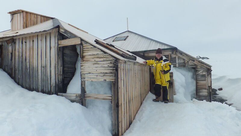 David Ellyard stands outside Mawson’s Main Hut, surrounded by snow and ice.