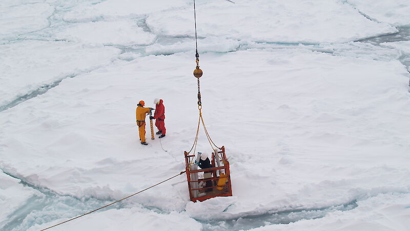 Scientists collect an ice core on an ice floe.