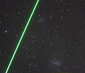 Green LIDAR beam across a starry sky