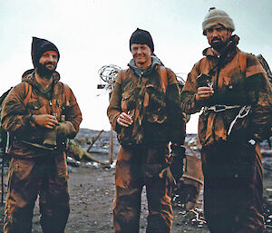 The Mountain Party share a tot of whisky on arriving at the ANARE Station, Heard Island, after their retreat from the summit plateau of Big Ben.