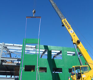The panels being lifted onto the steel frame of the building