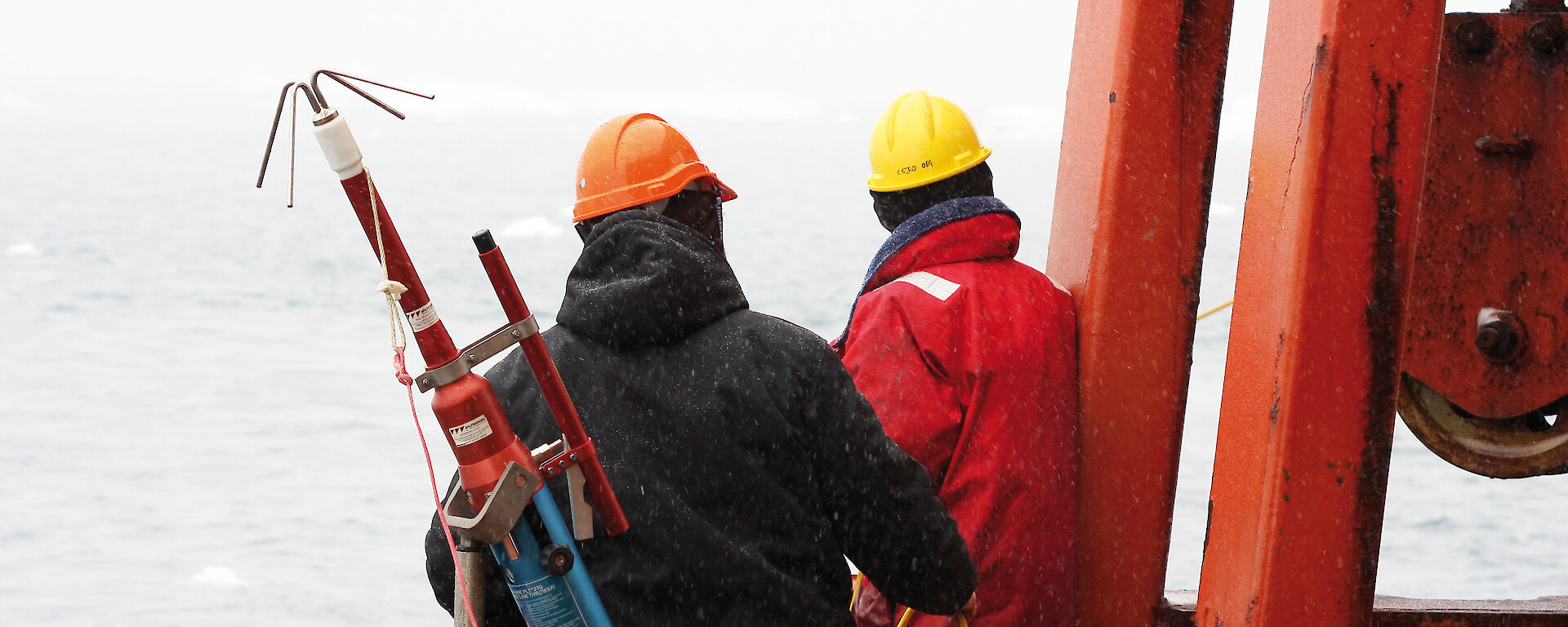 Aurora Australis crew ready a grappling hook to capture a fibre optic gyro released from an ocean mooring