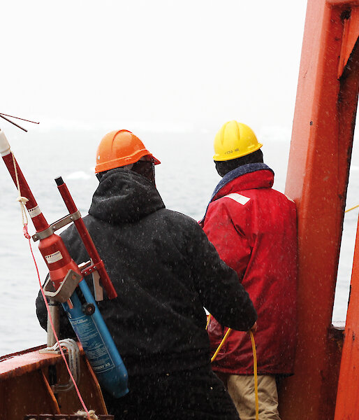 Aurora Australis crew ready a grappling hook to capture a fibre optic gyro released from an ocean mooring