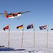 A Twin Otter flies over the flags of countries participating in AGAP.