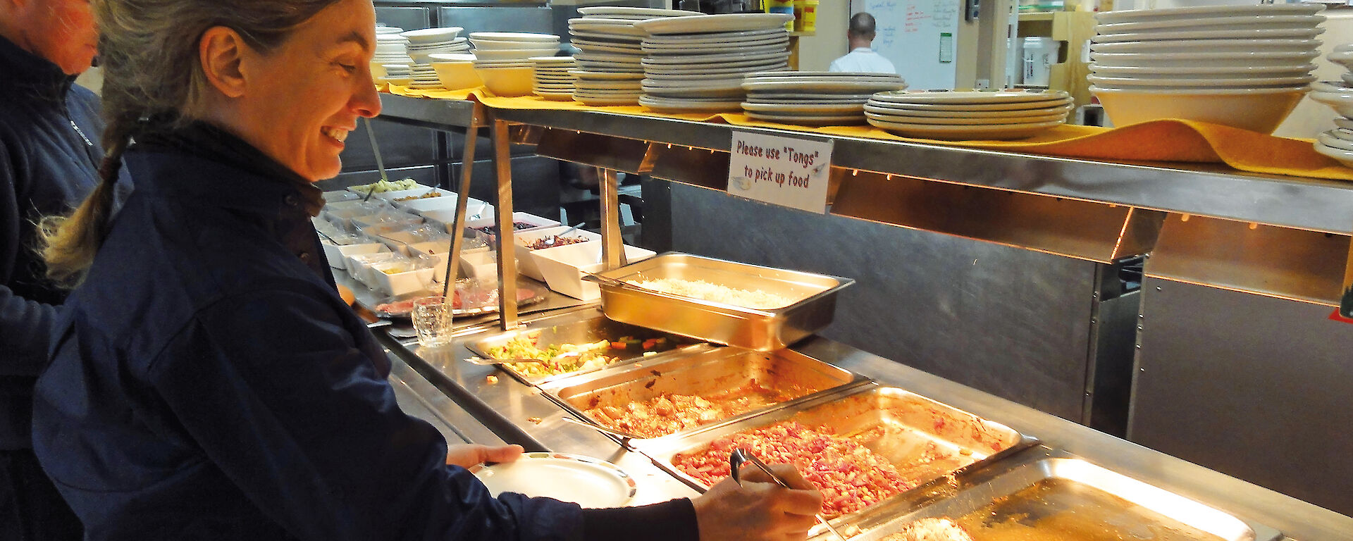 Expeditioner Sharon Robinson chooses a meal from the buffet at Australia’s Casey station.