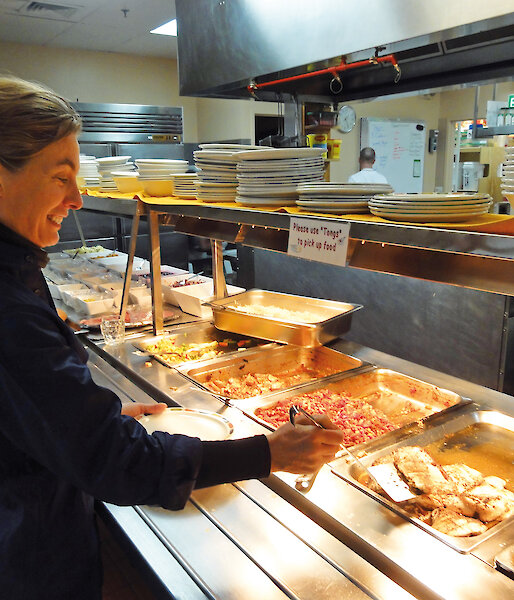 Expeditioner Sharon Robinson chooses a meal from the buffet at Australia’s Casey station.