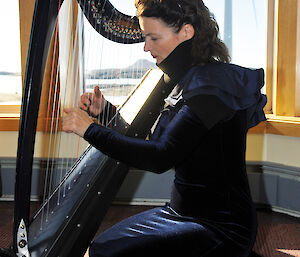 Alice practices her small lever harp at Mawson station.