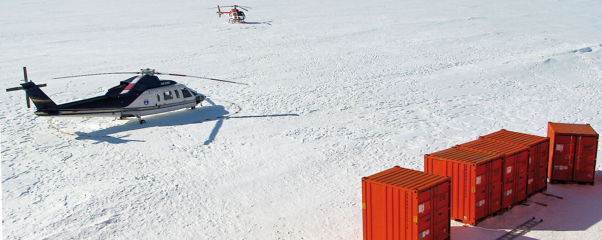 The Sikorsky S76 (left) and Squirrel helicopters during the Mawson resupply from the sea ice.