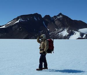 Expeditioner on plateau with Mt. Henderson in the background