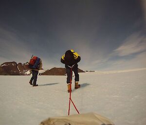 Expeditioners toiling uphill across the plateau