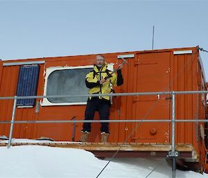 Expeditioner poses in front of Mt Henderson fileld hut