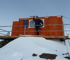 Expeditioner posing in front of Mt. Henderson field hut