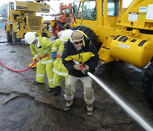 Station doctor mans a fire hose