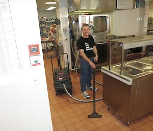 Expeditioner cleaning kitchen with ‘wet’ vacuum cleaner