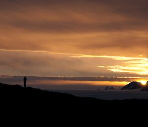 Almost a sunset — the Sun shines from behind Fang peak and lights up the sky orange