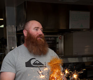 Expeditioner carries croquembouche with burning sparklers to the table