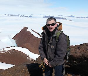 Ken standing on top of Mt. Henderson, looking towards Rumdoodle with Masson ranges in the background