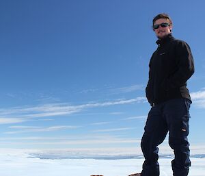 Nick standing on top of Mt. Henderson with the coast visible in the background