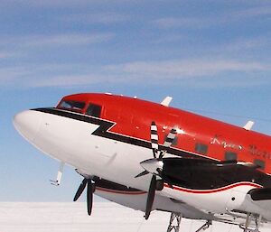 Red and white Basler modified DC-3 parked on its skis