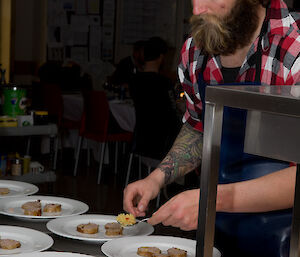 Expeditioner Josh assisting to plate up the second course of the meal