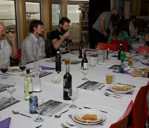 A group of diners around one of the two tables in the Mess