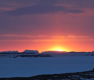 A colourful sunset over icebergs