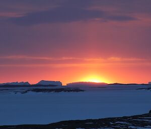 A colourful sunset over icebergs