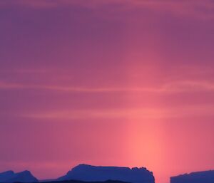 Following sunset, a vertical pillar of light (caused by refraction through ice crystals)