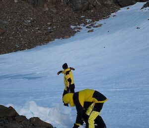 Expeditioner digging hole and blocks to shelter from the wind in bivvy bag