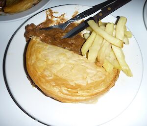 Half a pie and chips on a plate
