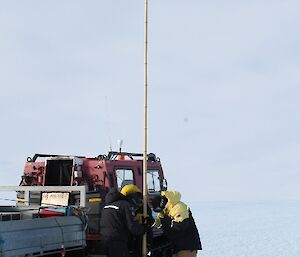 Expeditioner standing next to cane securely in the Ice