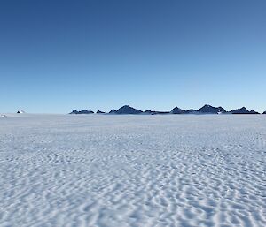 Featureless Ice Plateau with mountain range in distance