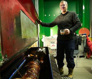 Expeditioner checking the cooking of the spit-roasted pig