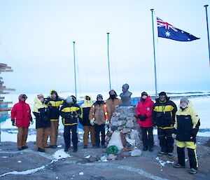 Expeditioners in front of the Mawson flagpoles just after dawn