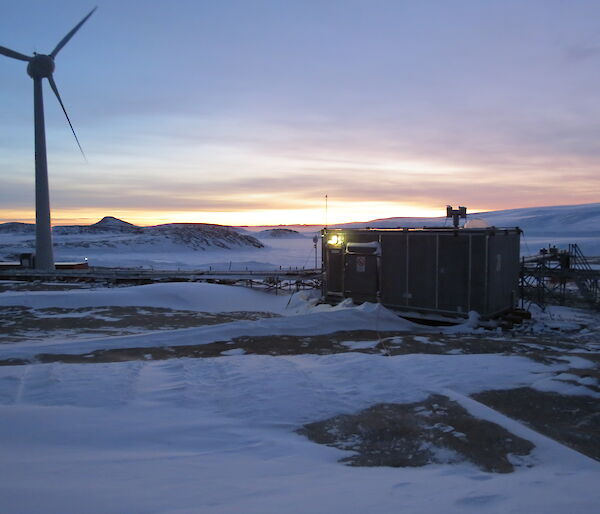 Silver hydroponics hut in foreground with sun rise in background