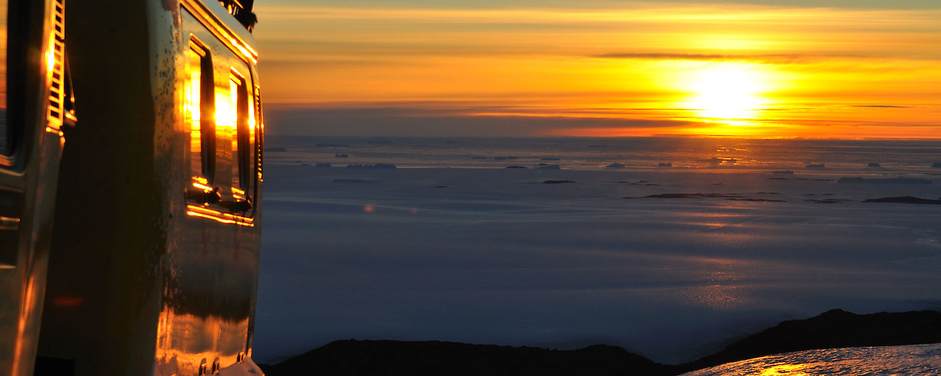 Beautiful colours of sunset reflecting off sea ice, plateau ice and Hägglunds at the same time