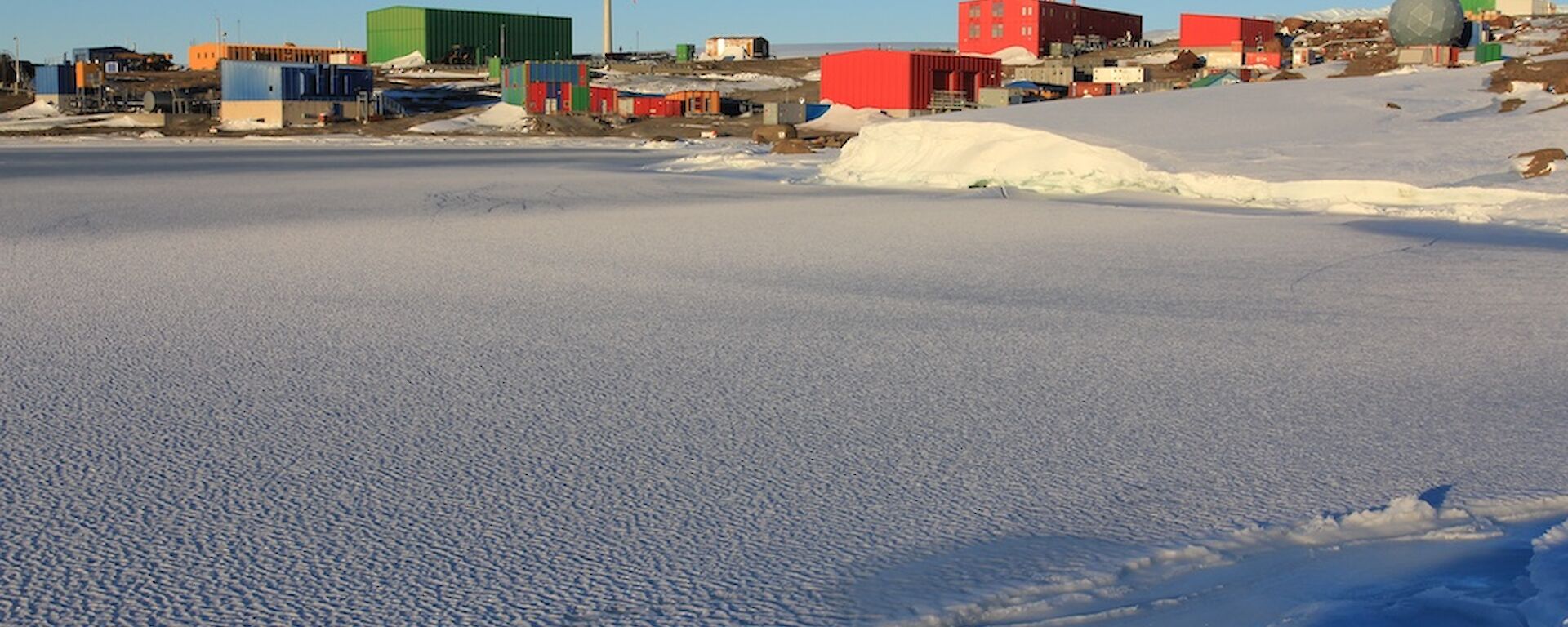 View of Mawson station with sea ice in the foreground.