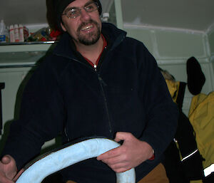 Carpenter holding the repaired blue foam toilet seat