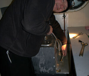 The plumber disconnecting the gas supply to the old stove