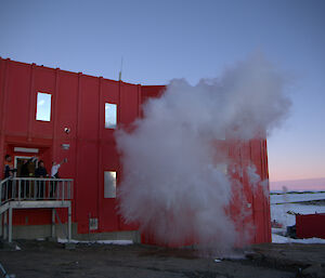 The vapor cloud is getting bigger and moving to the right as the building and building are on the left