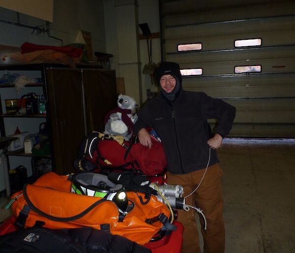 A quad bike prepared for sea-ice travel with a koala named Bear Grylls on the bike and an expedioner standing beside the vehicle