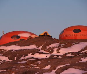 The two fibreglass shelters shaped like smarties with an expeditioner lying betwen them taking photos